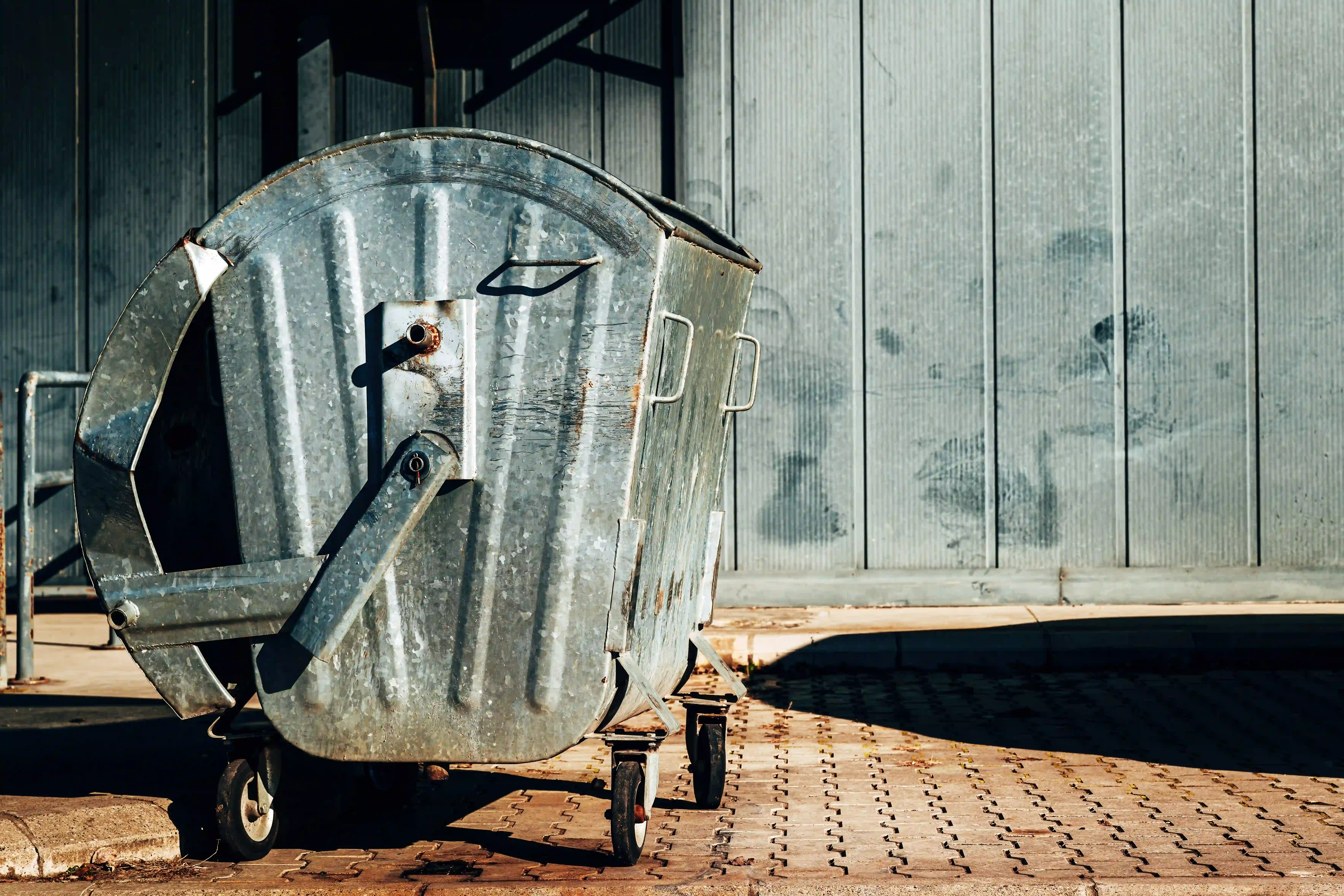 metallic-trash-dumpster-container-in-front-of-indu